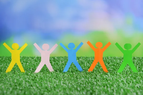 Paper people on green grass, close up — Stock Photo, Image