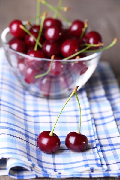 Cherries in color bowl on wooden background — Stock Photo, Image