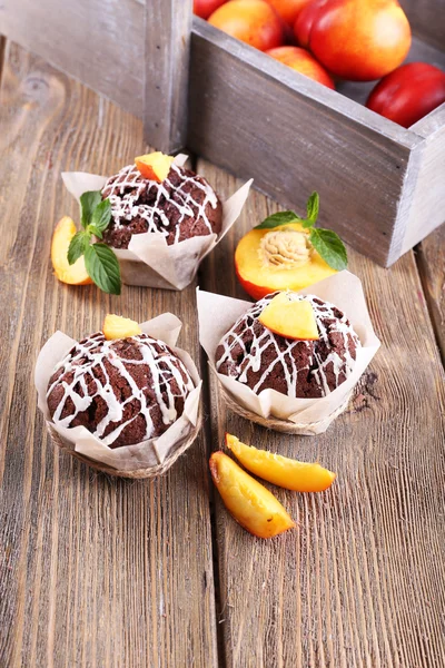 Tasty cupcakes with peach on table close-up — Stock Photo, Image