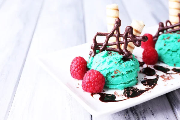 Chutné zmrzliny s čokoládové ozdoby a omáčka deskou, na barevné dřevěné pozadí — Stock fotografie