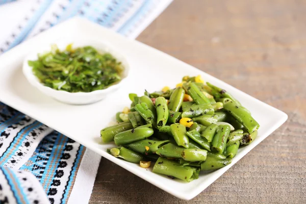 Salad with green beans and corn with sauce on plate , on color wooden background — Stock Photo, Image