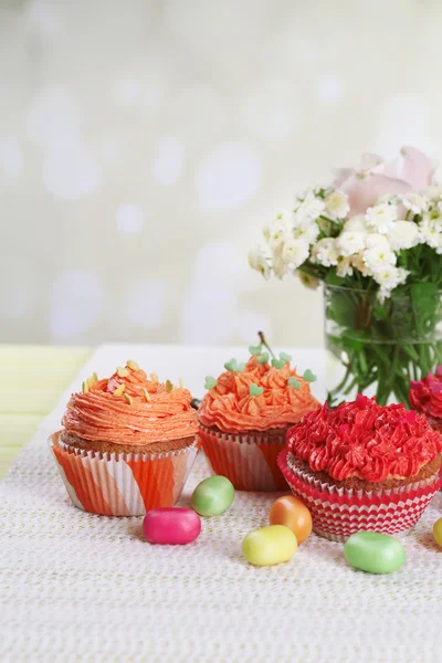 Cupcakes saborosos na mesa, no fundo brilhante — Fotografia de Stock