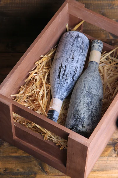 Garrafas de vinho em caixa de madeira, sobre fundo de madeira — Fotografia de Stock