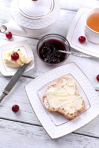 Verse toast met zelfgemaakte boter op plaat op houten achtergrond — Stockfoto