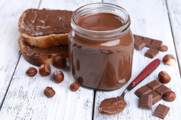 Sweet chocolate cream in jar on table close-up — Stok Foto