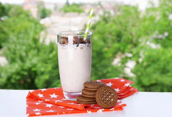 Mléko koktejl ve skle a čokoládové sušenky na stůl na přírodní pozadí — Stock fotografie