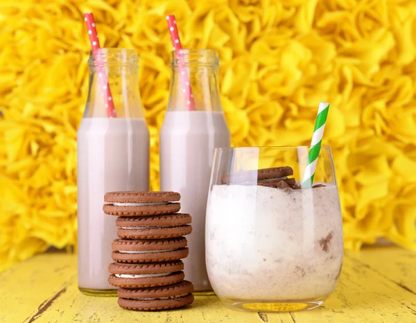 Cócteles de leche en vasos y galletas de chocolate sobre fondo amarillo —  Fotos de Stock