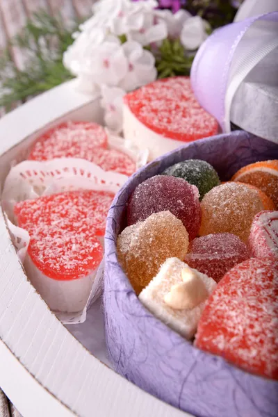 Caja de regalo con dulces y flores de cerca —  Fotos de Stock