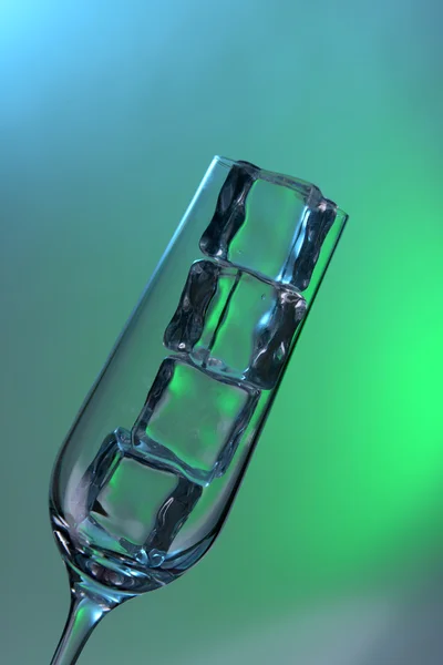 Glass with ice cubes on color background — Stock Photo, Image