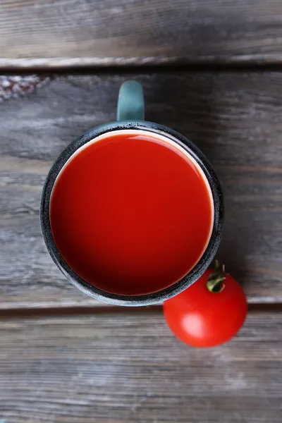 Jugo de tomate casero en taza de color y tomates frescos sobre fondo de madera —  Fotos de Stock