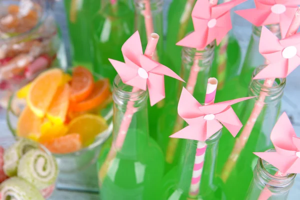 Flaskor med dryck och godis på bordet på nära håll — Stockfoto