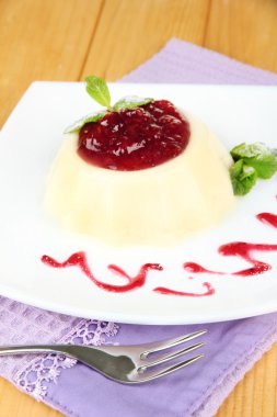 Panna cotta ahşap zemin üzerinde frambuaz sos ile