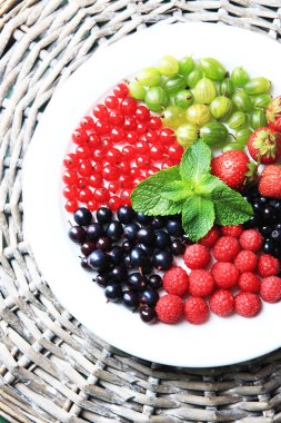 Orman meyveleri tabağa renk ahşap arka plan üzerinde