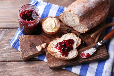 taze ekmek ile ev yapımı tereyağı ve blackcurrant jam ahşap arka plan üzerinde