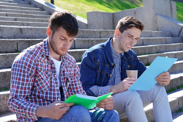 Estudiantes sentados en escaleras — Foto de Stock