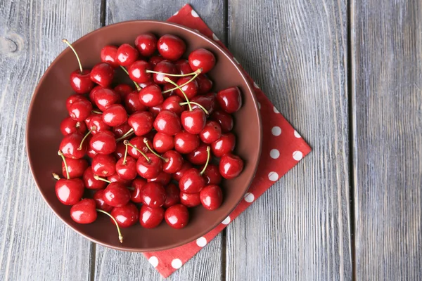 Cerises douces sur assiette sur fond en bois — Photo