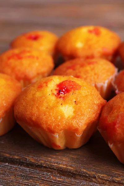 Smakelijke muffins met rode bes op houten achtergrond — Stockfoto