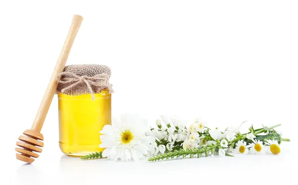 Pot rempli de délicieux miel frais et de fleurs sauvages, isolé sur blanc — Photo