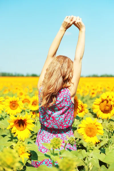 Jonge vrouw in zonnebloem veld — Stockfoto