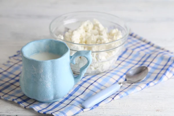 Kopp mjölk och keso i glasskål på trä bakgrund — Stockfoto