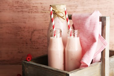pembe ahşap zemin üzerine lezzetli frambuazlı smoothie içki şişeleri
