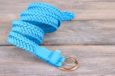 ahşap zemin üzerinde mavi deri kemer