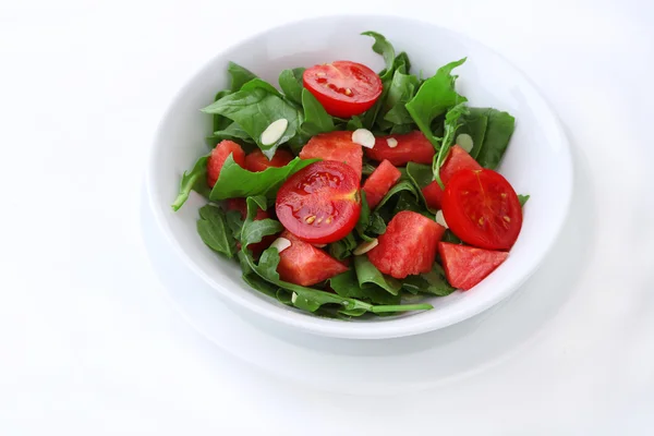 Salat mit Wassermelone, Zwiebel, Rucola und Spinatblättern auf Teller, isoliert auf weißem — Stockfoto