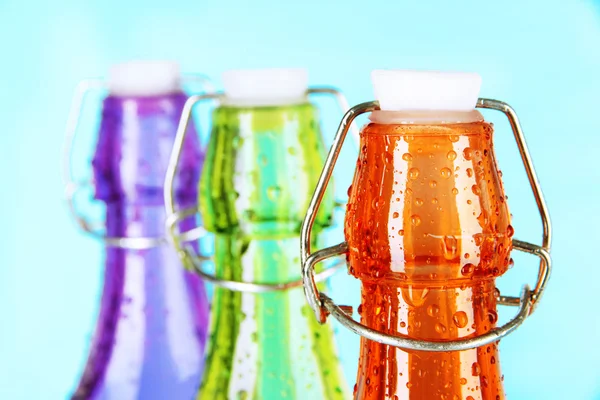 Colorful bottles on light blue background — Stock Photo, Image