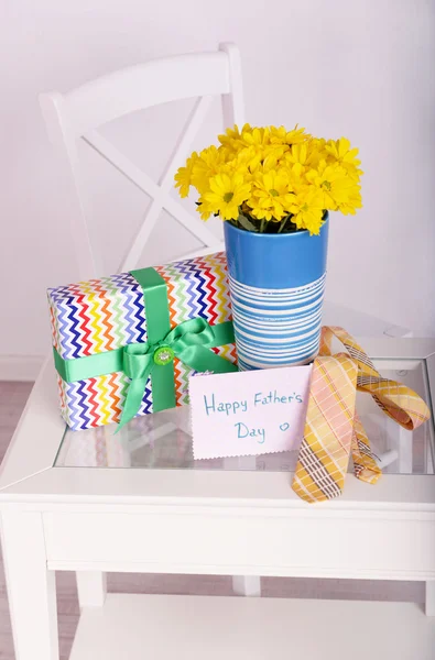 Bouquet of flowers, gift box and tie on Fathers Day in room — Stock Photo, Image