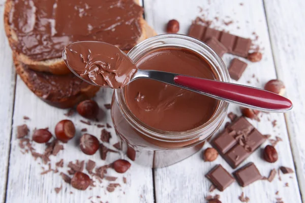 Sweet chocolate cream in jar on table close-up — Stock Photo, Image