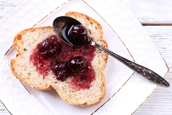 Verse toast met zelfgemaakte boter op plaat op houten achtergrond — Stockfoto