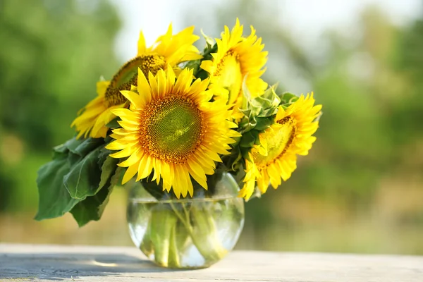 Krásné slunečnice na stole na světlé pozadí — Stock fotografie