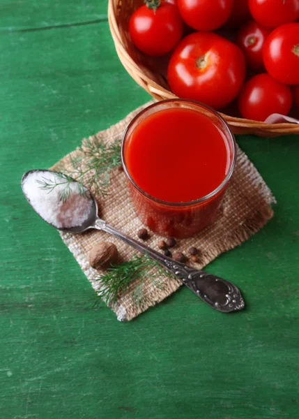 Jugo de tomate casero en vaso, especias y tomates frescos sobre fondo de madera — Foto de Stock