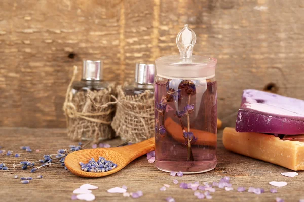 Spa still life with lavender oil and flowers on wooden table — Stock Photo, Image
