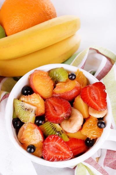 Fresh fruits salad in bowl on napkin close up — Stock Photo, Image