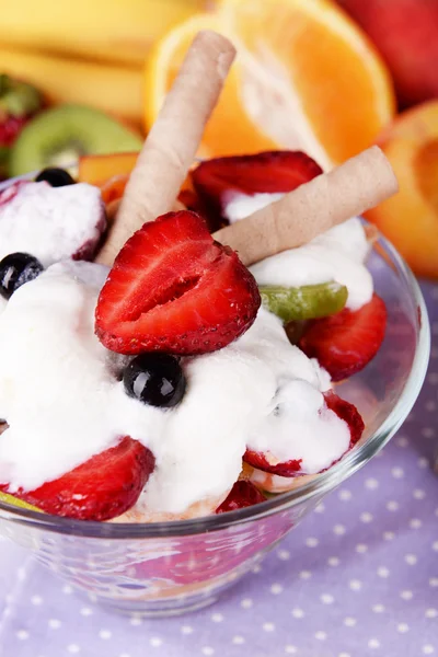 Свежий фруктовый салат с мороженым в миске и фрукты на столе близко — стоковое фото