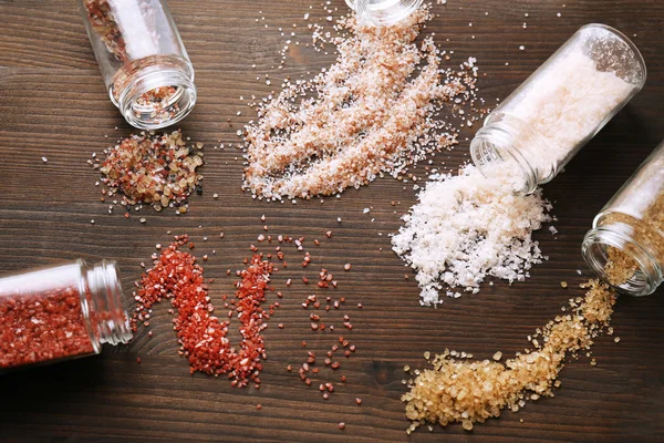 Разнообразная морская соль, разбросанная по столу — стоковое фото