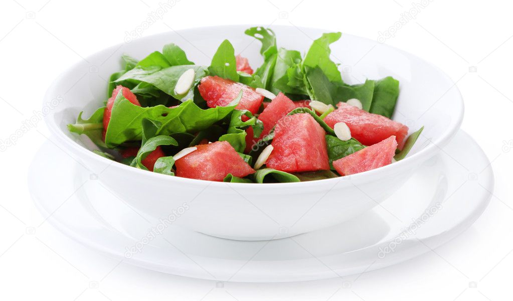 Salad with watermelon, onion, arugula and spinach leaves on plate, isolated on white