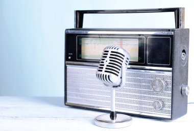 Vintage mikrofon ve masanın üzerine açık mavi renkli radyoda