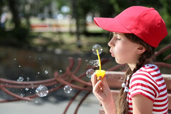 Girl blowing soap bubbles — Stock Photo, Image