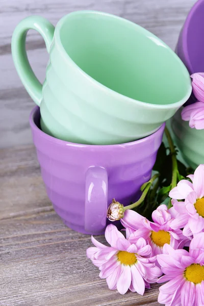 Platos brillantes con flores sobre fondo de madera — Foto de Stock