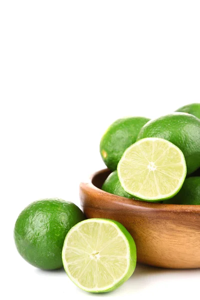 Fresh juicy limes in wooden bowl, isolated on white — Stock Photo, Image