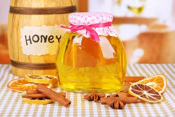 Jar of honey, wooden barrel, drizzler and dried lemon slices on bright background — Stock Photo, Image