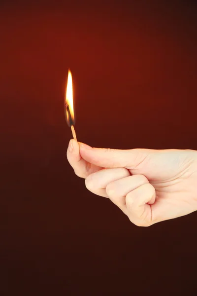 Branden wedstrijd in vrouwelijke hand — Stockfoto