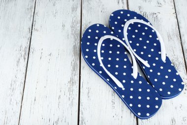 ahşap arka plan üzerinde renkli parmak arası terlik