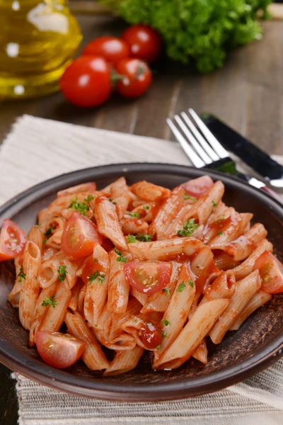 Pasta met tomatensaus op plaat op tabel close-up — Stockfoto