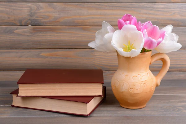 Vackra tulpaner i hink i kruka på bordet på grå bakgrund — Stock fotografie