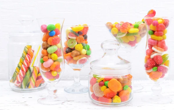 Różnych kolorowych owocowych cukierków w okularach na stole na jasnym tle — Zdjęcie stockowe