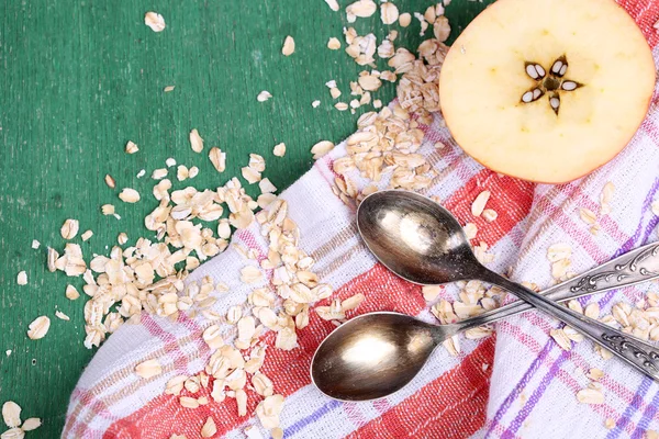 Apple with oatmeal and vintage spoons — Stock Photo, Image