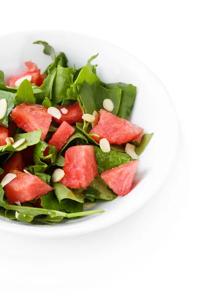 Salada com melancia, cebola, rúcula e folhas de espinafre no prato, isolado em branco — Fotografia de Stock